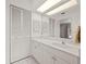 Bright bathroom featuring white cabinets, a large mirror, and closet for ample storage at 6101 Willow Oak Cir, Bradenton, FL 34209