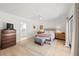 Bright bedroom with en suite bath, light wood floors, and sliding door access to backyard at 6101 Willow Oak Cir, Bradenton, FL 34209