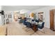 Open-concept dining area with a modern table, chairs, hardwood floors, and seamless integration with the living area and patio at 6101 Willow Oak Cir, Bradenton, FL 34209