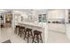 Bright kitchen with white cabinetry, long breakfast bar, and view to outdoor pool at 6101 Willow Oak Cir, Bradenton, FL 34209