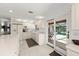Bright kitchen with white cabinets and appliances, including adjacent dining area with a view of pool at 6101 Willow Oak Cir, Bradenton, FL 34209