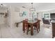 Open dining area with tile flooring and a rustic wooden table, open to living room at 6188 80Th N St # 101, St Petersburg, FL 33709