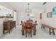 Open dining area with tile flooring and a rustic wooden table, open to kitchen at 6188 80Th N St # 101, St Petersburg, FL 33709