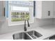 Kitchen window view of a pond and fountain, complemented by sleek countertops and stainless steel appliances at 6188 80Th N St # 101, St Petersburg, FL 33709