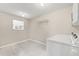 Bright laundry room with a window, tiled floors, washer, overhead rack, and white cabinets at 6188 80Th N St # 101, St Petersburg, FL 33709
