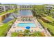 Aerial view of a community pool with lounge chairs, shaded area, and view of the water at 6188 80Th N St # 101, St Petersburg, FL 33709