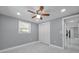 Comfortable bedroom with neutral walls, a ceiling fan, and bright, natural light from the window at 6309 7Th Ave, New Port Richey, FL 34653