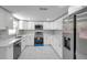 Modern kitchen featuring stainless steel appliances, marble floors, and white cabinetry at 6309 7Th Ave, New Port Richey, FL 34653