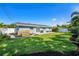 Large backyard with healthy green grass featuring a patio area with outdoor furniture at 6490 22Nd S St, St Petersburg, FL 33712