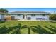 Backyard featuring a patio with outdoor seating and lush lawn under a clear blue sky at 6490 22Nd S St, St Petersburg, FL 33712