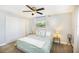 Bright bedroom featuring a ceiling fan, a window with white curtains, and a spacious closet at 6490 22Nd S St, St Petersburg, FL 33712