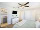 Bright main bedroom featuring a ceiling fan, tv, a modern dresser and a spacious closet at 6490 22Nd S St, St Petersburg, FL 33712