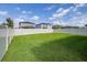 Spacious backyard featuring lush green grass and an elegant white perimeter fence at 6563 Ryestone Way, Wesley Chapel, FL 33545