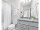 Bright bathroom featuring granite countertops, tile floors, and a shower-tub combo with curtain at 6563 Ryestone Way, Wesley Chapel, FL 33545
