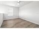 A secondary bedroom displays light, wood-look floors and a ceiling fan at 6563 Ryestone Way, Wesley Chapel, FL 33545
