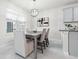 Bright dining area with a modern chandelier, gray table set, and view of the backyard at 6563 Ryestone Way, Wesley Chapel, FL 33545