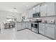 Modern kitchen with gray cabinets, stainless steel appliances, granite countertops and open to dining area at 6563 Ryestone Way, Wesley Chapel, FL 33545