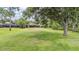 A lush green backyard with trees, beautiful lawn, and an enclosed porch on the back of the house at 707 Warren Rd, Lutz, FL 33548