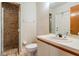 Tiled bathroom featuring a glass shower stall, white toilet and a single sink vanity at 707 Warren Rd, Lutz, FL 33548