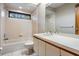 Bright bathroom with a combination tub and shower, tiled walls, and a large vanity at 707 Warren Rd, Lutz, FL 33548
