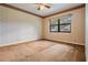 Neutral bedroom with a ceiling fan and natural light streaming through the large window at 707 Warren Rd, Lutz, FL 33548