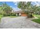 A single story home with a large driveway and mature landscaping at 707 Warren Rd, Lutz, FL 33548