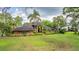 Charming home with beautiful lawn, palm trees and mature landscaping at 707 Warren Rd, Lutz, FL 33548