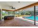Stunning pool and hot tub area with screened enclosure, brick patio, and lush landscaping at 707 Warren Rd, Lutz, FL 33548