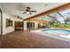 Inviting pool area with a screened enclosure, brick patio, and covered seating for relaxation at 707 Warren Rd, Lutz, FL 33548