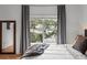 Bright bedroom with hardwood floors, large window, mirror, and gray and white bedding at 727 Coral Reef Dr, Tampa, FL 33602