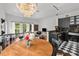 Bright dining area features a modern chandelier, black cabinets, and black and white checkered floors at 727 Coral Reef Dr, Tampa, FL 33602