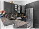 Modern kitchen with black marble countertops and cabinets, stainless steel appliances, and sleek finishes at 727 Coral Reef Dr, Tampa, FL 33602