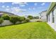 Expansive green backyard with thriving vegetation, a sturdy white fence, and an overall sense of privacy and tranquility at 751 Cajeput Loop, Tarpon Springs, FL 34689