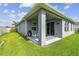 Spacious backyard with a covered patio, lush green lawn, and partial fencing for added privacy at 751 Cajeput Loop, Tarpon Springs, FL 34689