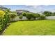 Lush backyard with manicured landscaping and a sturdy white fence, offering privacy and a picturesque outdoor setting at 751 Cajeput Loop, Tarpon Springs, FL 34689