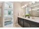 Elegant bathroom with a double vanity, quartz countertops, and a view of the connecting bedroom at 751 Cajeput Loop, Tarpon Springs, FL 34689
