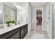 Bathroom with double vanity, quartz countertops, walk-in closet, and glass-enclosed shower at 751 Cajeput Loop, Tarpon Springs, FL 34689
