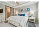 Comfortable bedroom featuring a sliding barn door to the ensuite bath, shiplap ceiling and coastal decor at 751 Cajeput Loop, Tarpon Springs, FL 34689