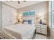 Comfortable bedroom with a white bed, matching nightstands, and a coastal painting at 751 Cajeput Loop, Tarpon Springs, FL 34689