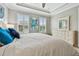 Bright bedroom with plantation shutters, a white dresser, and a king bed with blue accent pillows at 751 Cajeput Loop, Tarpon Springs, FL 34689
