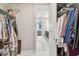 Walk-in closet leading to a bedroom showcasing white tile flooring and easy access to bedroom and bathroom at 751 Cajeput Loop, Tarpon Springs, FL 34689