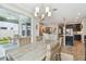 Bright dining room with woven chairs, stylish chandelier, and sliding glass doors to the outdoor patio at 751 Cajeput Loop, Tarpon Springs, FL 34689