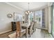 Elegant dining room with a rustic table, woven chairs, and ample natural light at 751 Cajeput Loop, Tarpon Springs, FL 34689