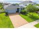 Charming single-story home boasts a brick driveway and well-manicured lawn with inviting curb appeal at 751 Cajeput Loop, Tarpon Springs, FL 34689