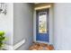 Close-up of the front door featuring a decorative glass window and brick-tiled entryway at 751 Cajeput Loop, Tarpon Springs, FL 34689