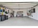 Well-lit two-car garage with epoxy flooring, organizational systems, and ample space for vehicles and storage at 751 Cajeput Loop, Tarpon Springs, FL 34689