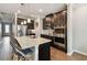 Modern kitchen featuring a large island, dark cabinetry, stainless steel appliances and wood floors at 751 Cajeput Loop, Tarpon Springs, FL 34689