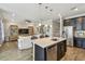 Open-concept kitchen island overlooks living area with stainless steel appliances and pendant lighting at 751 Cajeput Loop, Tarpon Springs, FL 34689