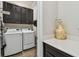 Well-equipped laundry room with sleek cabinetry, a countertop, and modern washer and dryer at 751 Cajeput Loop, Tarpon Springs, FL 34689