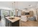 Open-concept living and dining area is connected to the kitchen and features wood flooring at 751 Cajeput Loop, Tarpon Springs, FL 34689